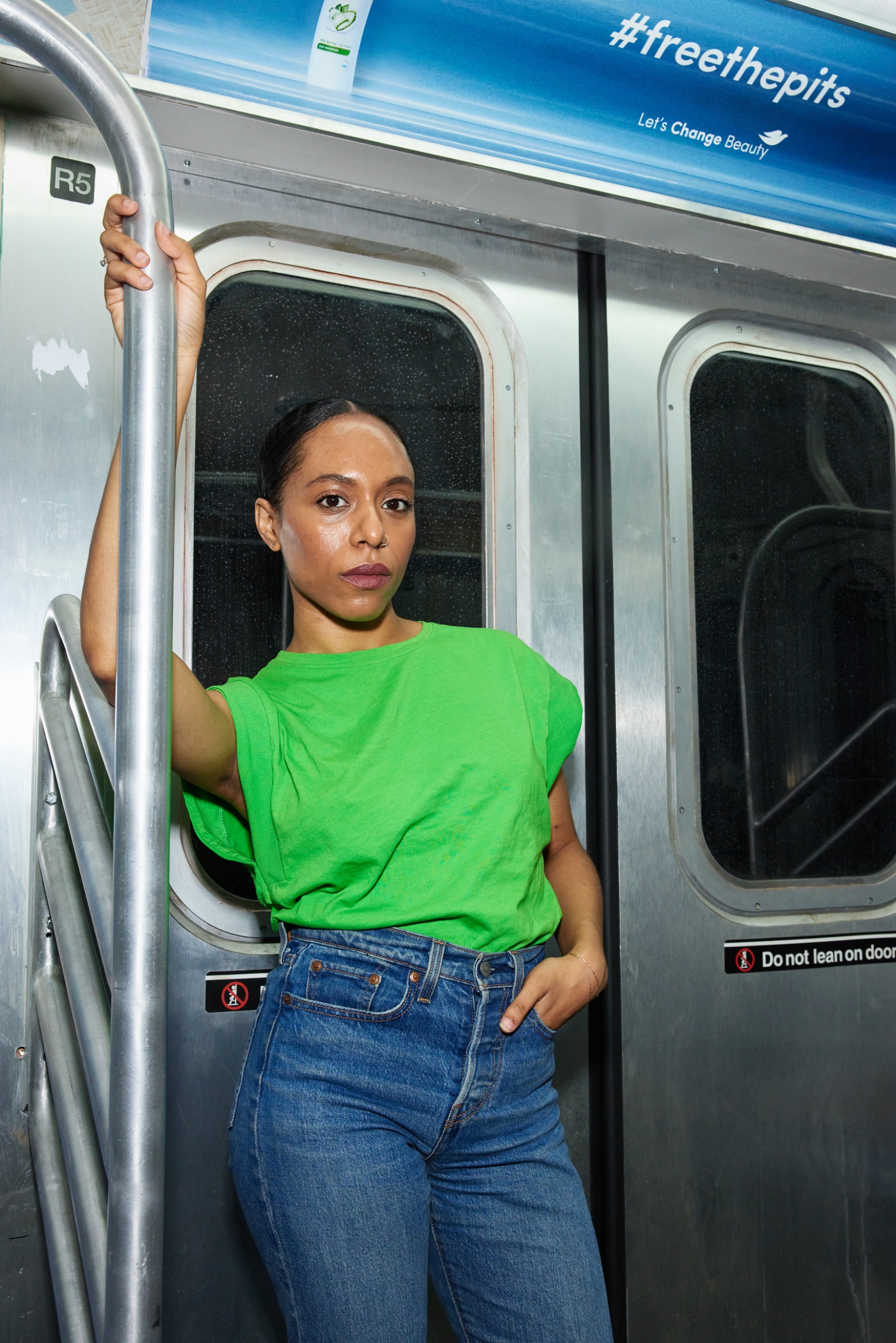 a black woman in a green top and blue jeans