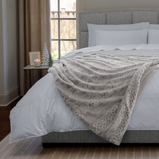 Classic Faux Fur Throw Blanket on a white comforter on a bed. 