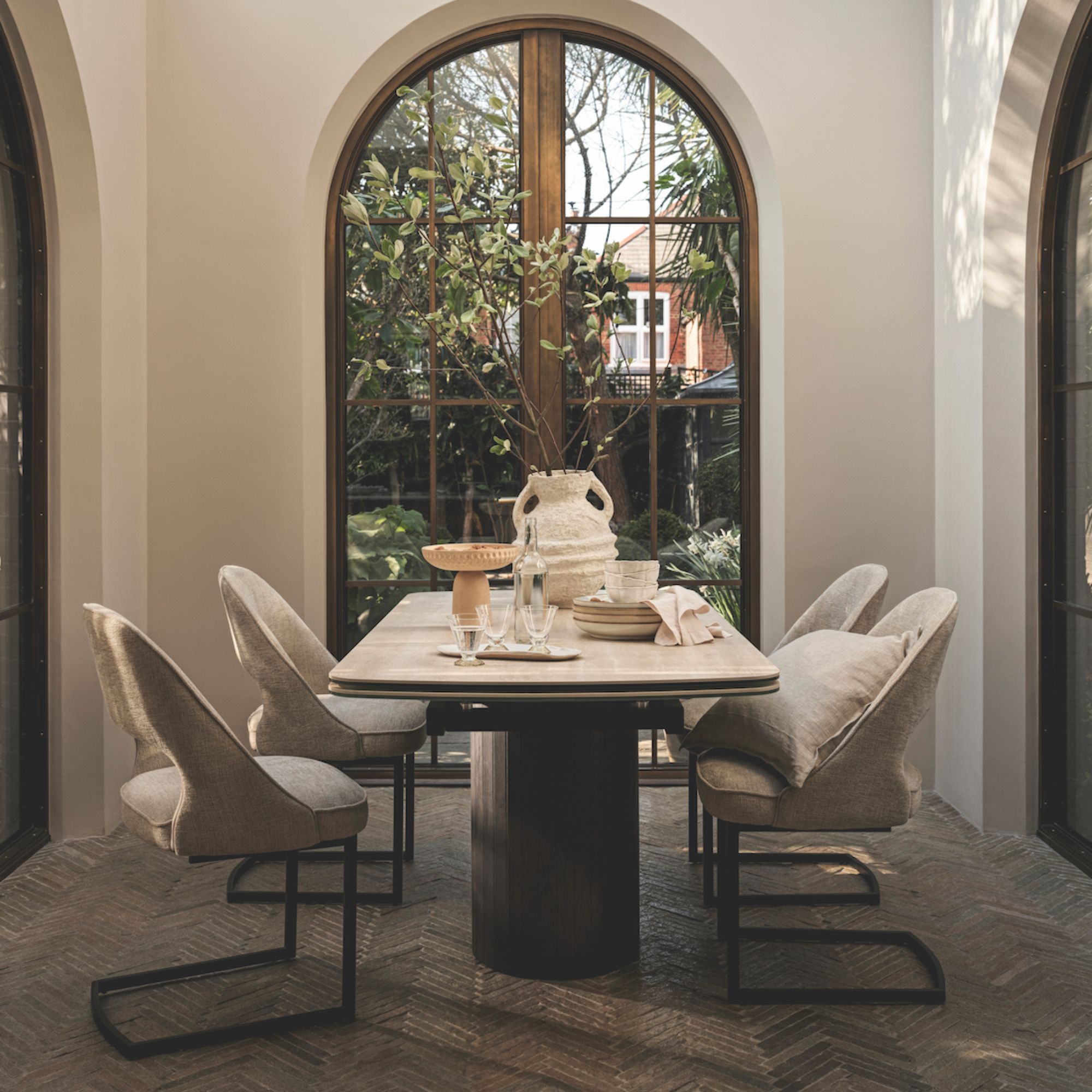 A dark wood dining table and material chairs in a neutral dining room