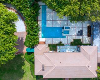 aerial view of large home with pool and lots of trees