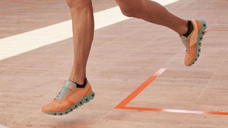 On Cloud X shoes review: model wearing the men's orange/sea colorway