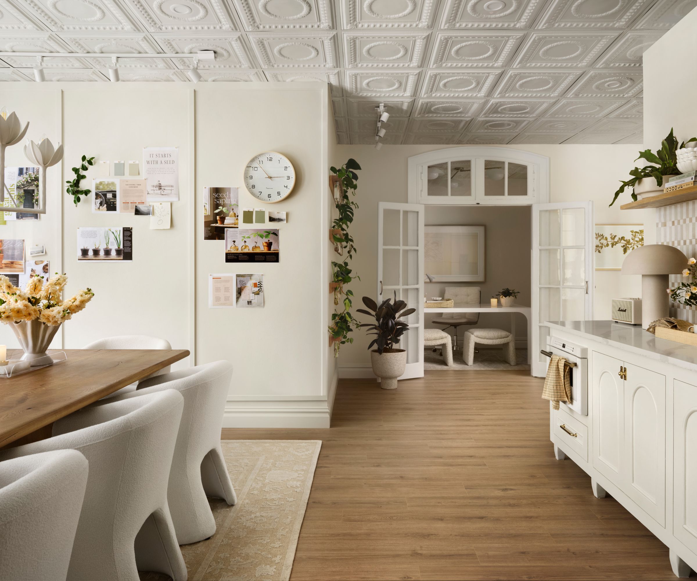 Office with molded ceiling, long wood table and dining chairs, cork board and wood floor