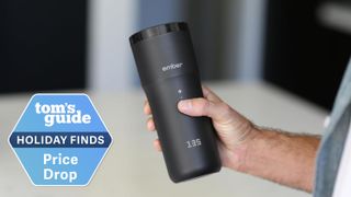 The Ember TravelMug 2+ being held in a man's hand with the temperature display visible