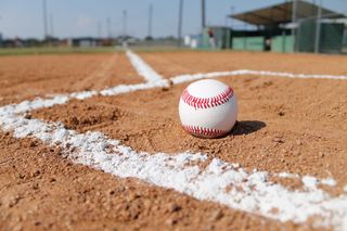 A baseball on the dirt near home plate
