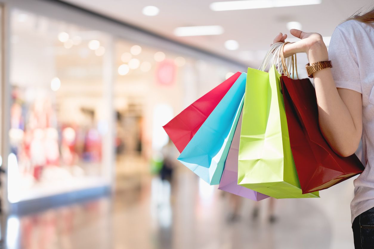 A woman carries shopping bags.