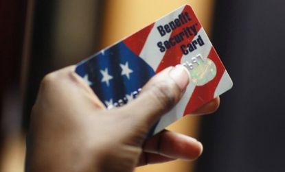 A Florida woman holds her Federal food stamp card