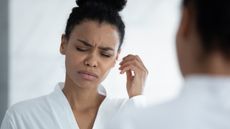 Woman cleaning her ear with a cotton swab.