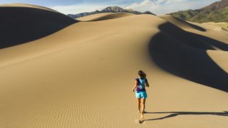 A woman hikes on the great sand dunes in colorado
