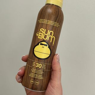 Laura holding Sun Bum Premium Moisturising Sunscreen Spray - best sun creams