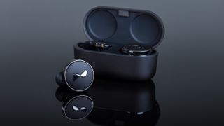 NuraTrue Pro earbuds with charging case open on a highly reflective black surface