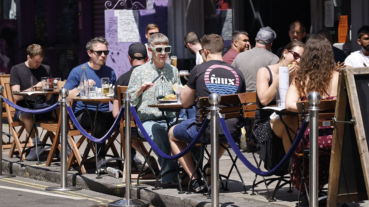 People at tables outside a restaurant