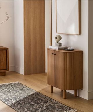 A small entryway with a wooden console table and wall art