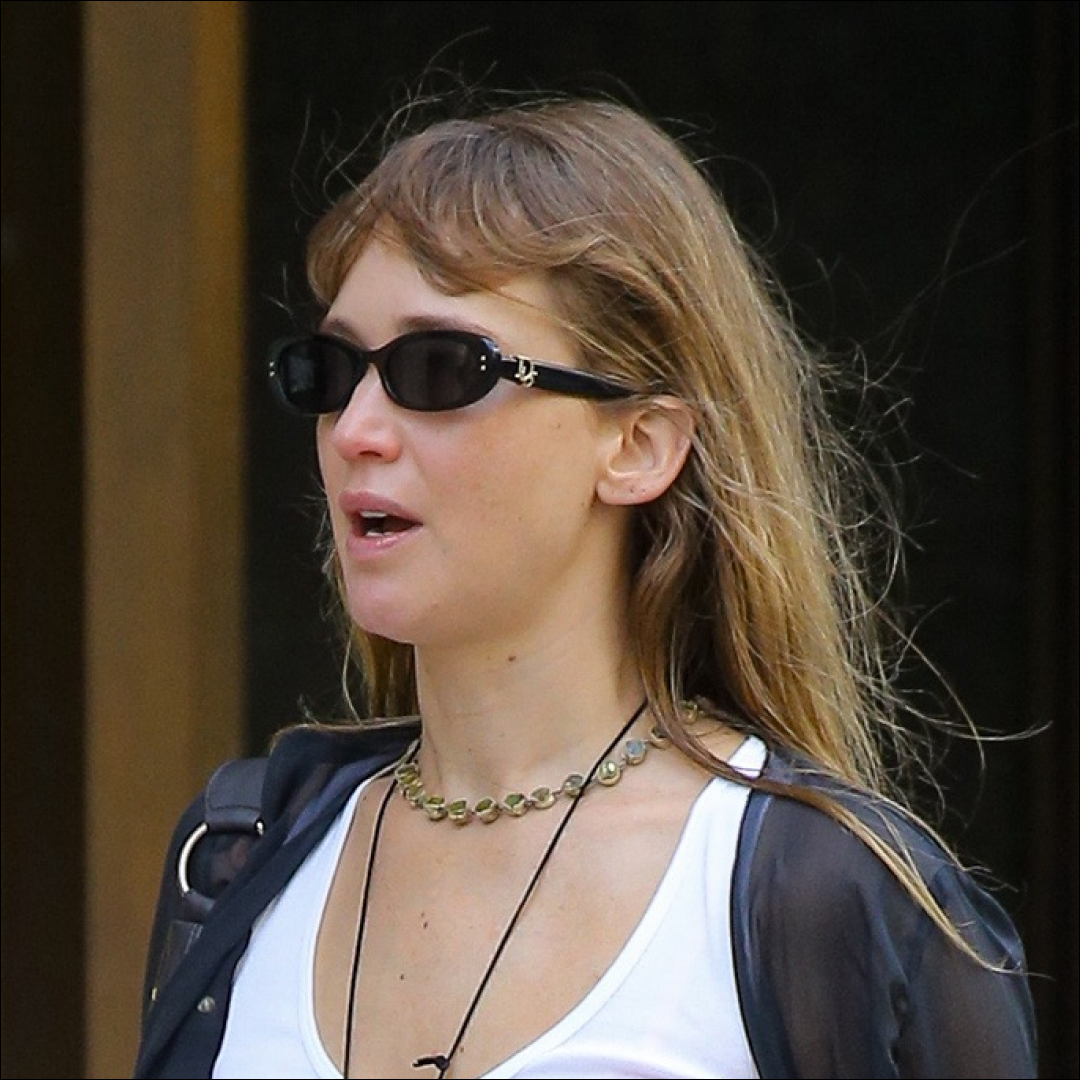 Jennifer Lawrence wearing khaki pants, flip-flops in fall, a white vest and sunglasses