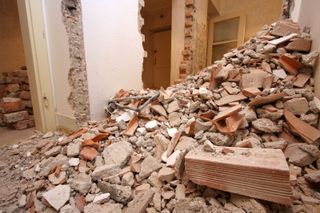 Big pile of bricks and rubble inside a house which has had a wall taken down