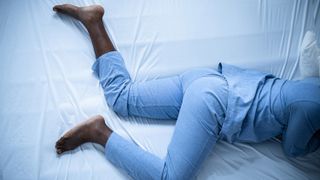 A person lying in bed with restless legs syndrome