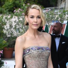 A woman with chin-length blonde hair wearing a strapless dress.