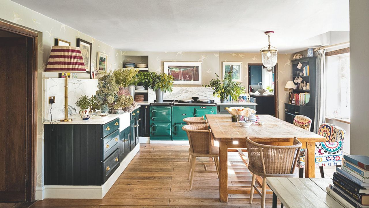 Bright kitchen diner with green cabinets and range cooker