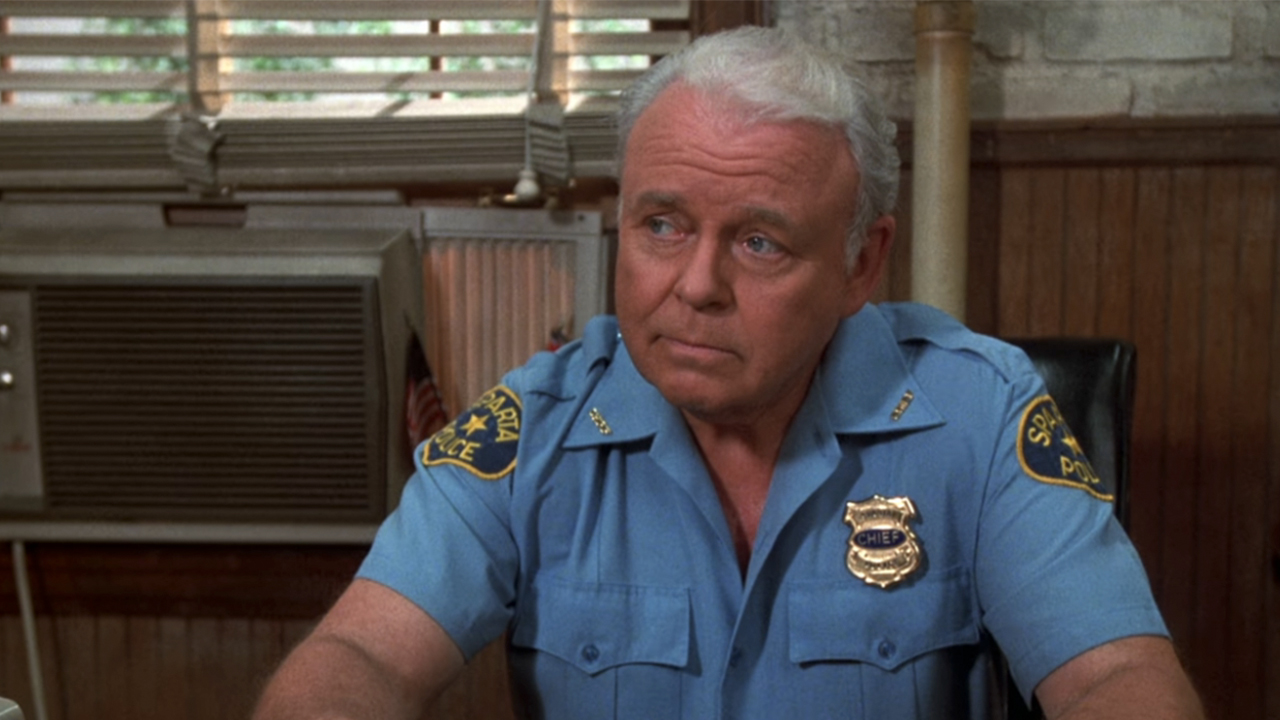 Carroll O&#039;Connor in a police uniform, looking to the side in In The Heat Of The Night