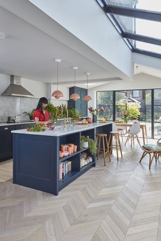 Kitchen extension with large kitchen island and herringbone wood flooring