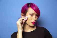 A person applies product to their face.