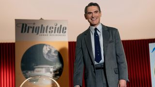 Jack Billings (Billy Crudup) on a stage selling timeshares on the moon.