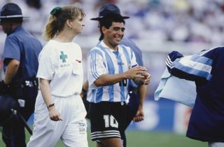 Diego Maradona leaves the pitch with a nurse for a random doping test after Argentina's game against Nigeria at the 1994 World Cup.