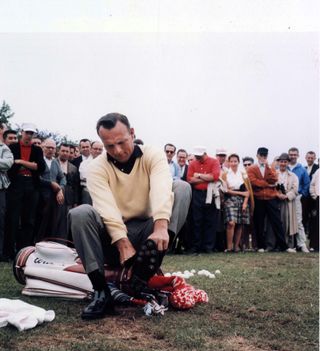 Golfer sitting on their bag putting shoes on