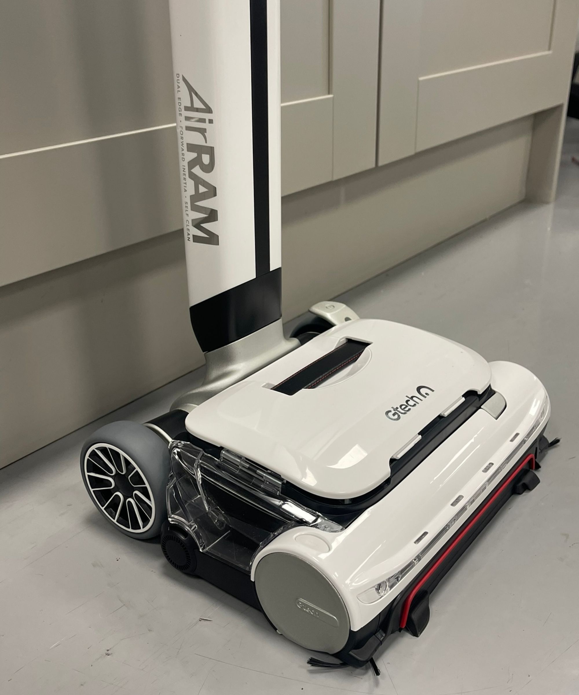 Closeup of the Gtech AirRAM 3 floorhead with black and white wheels, dust container and brushes in Future test center.