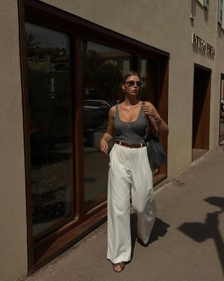 @vivianhoorn wearing trousers, a tank, and Hermès Oran sandals