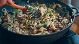 Beef stroganoff with mushrooms in a cast iron pan