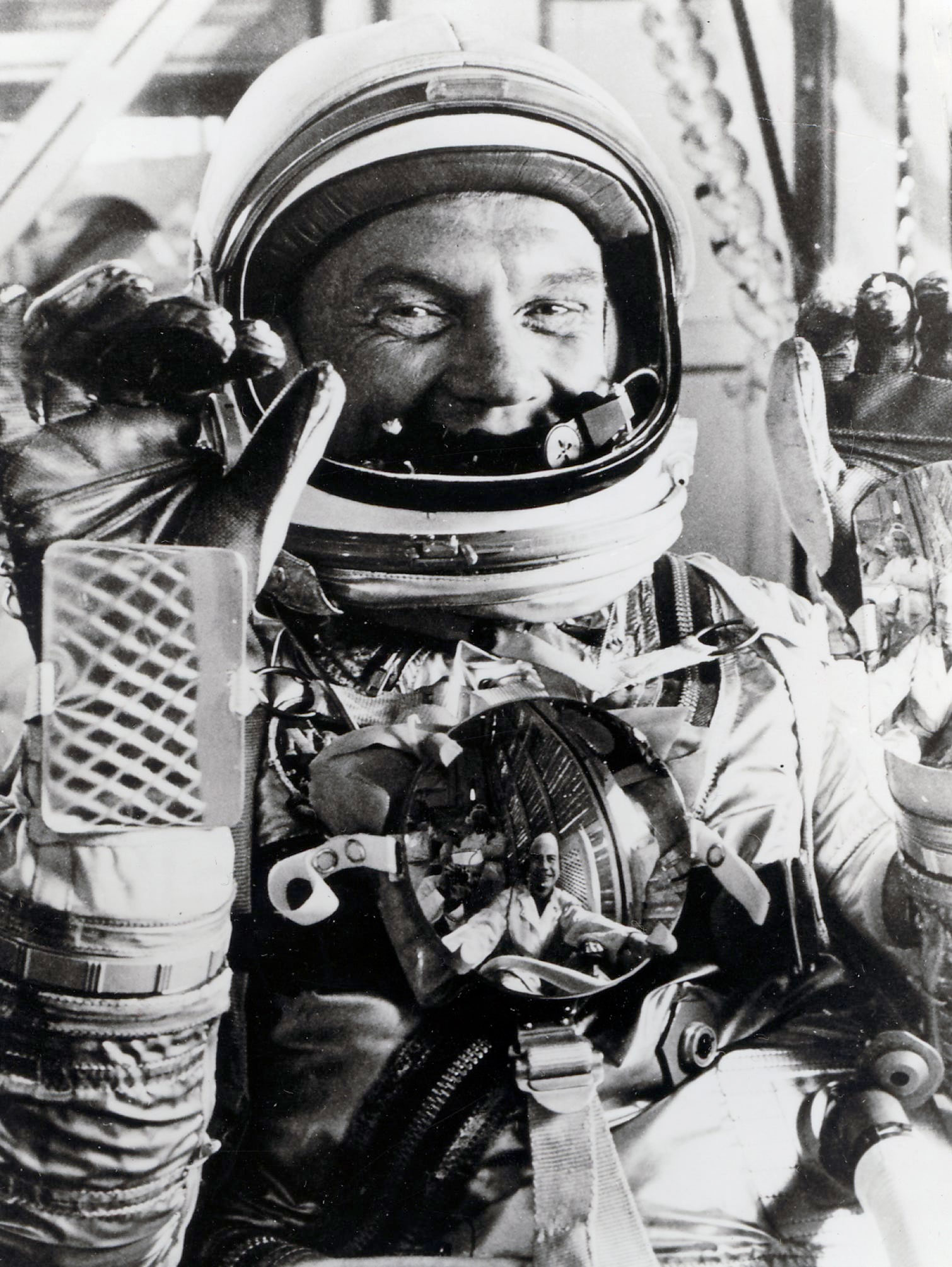 a black and white photo of a spacesuited astronaut giving a thumbs up