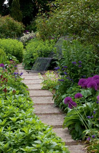 A slab and brick garden path in a sloping garden