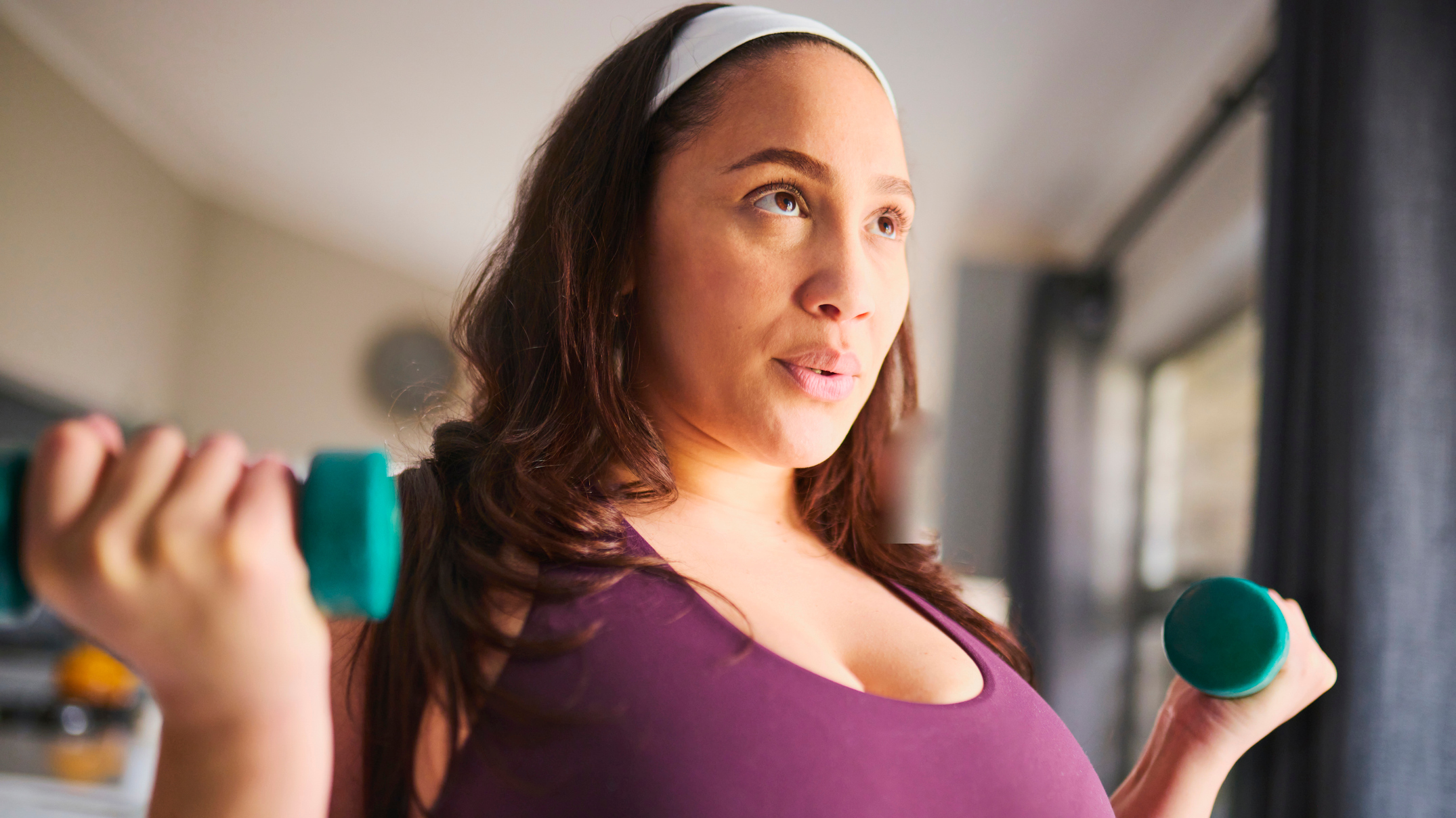 Woman exercising with dumbbells in a domestic setting