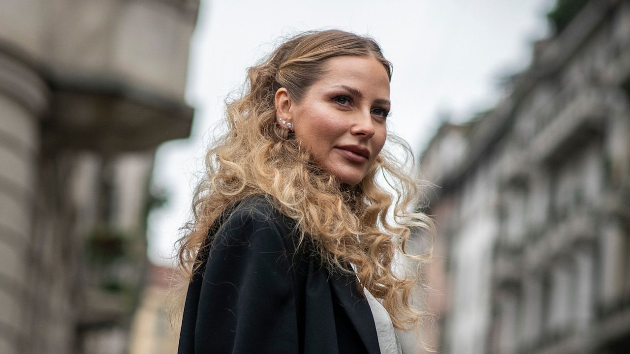 woman with curls from the best curling irons walking on the street 