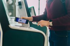 A woman scans her phone to check in at the airport.