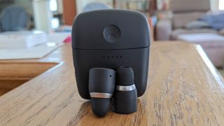 hero image for best apple airpods alternatives showing Cambridge Audio Melomania 1 Plus on a wooden table with charging case