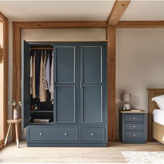 charcoal grey wardrobe in bedroom with wooden floor and beams