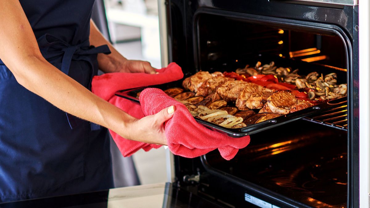 Woman putting food into oven