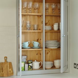 A kitchen cupboard filled with tableware and glassware