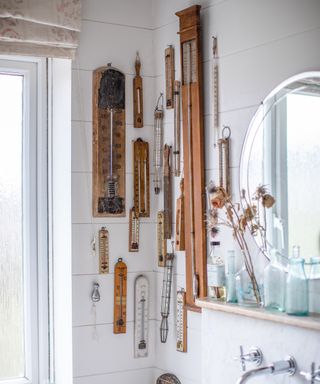 display of vintage thermometers on bathroom wall