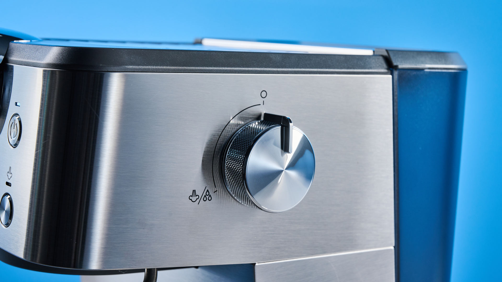 the De'Longhi Linea Classic espresso machine photographed against a blue tom's guide background, showing its silver finish, steam dial, steam wand, portafilter, and accessories