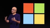 Microsoft CEO Satya Nadella in front of the Windows logo