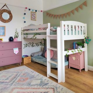 After photo garden themed kids bedroom with green wall. white bunk bed, pink chest of drawers
