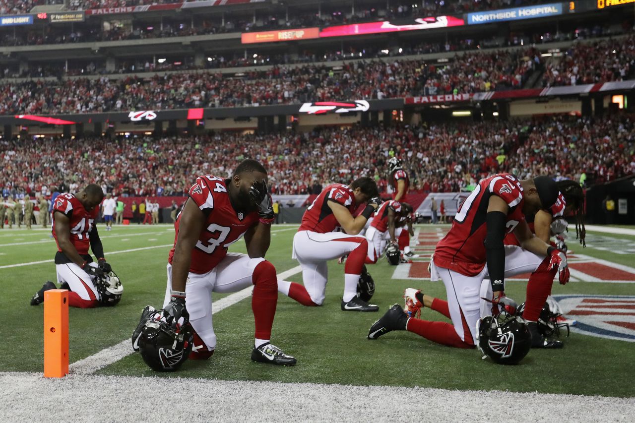 Atlanta Falcons players take a knee.