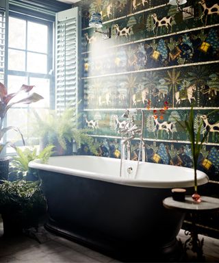 Maximalist bathroom wallpaper with black bathtub in foreground