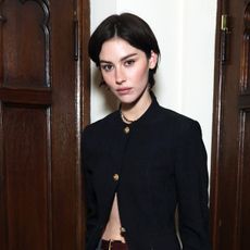 Gracie Abrams wearing a black blazer and gray trousers at the Coco Chanel event in Los Angeles