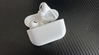 Apple AirPods Pro 2 on a black surface.