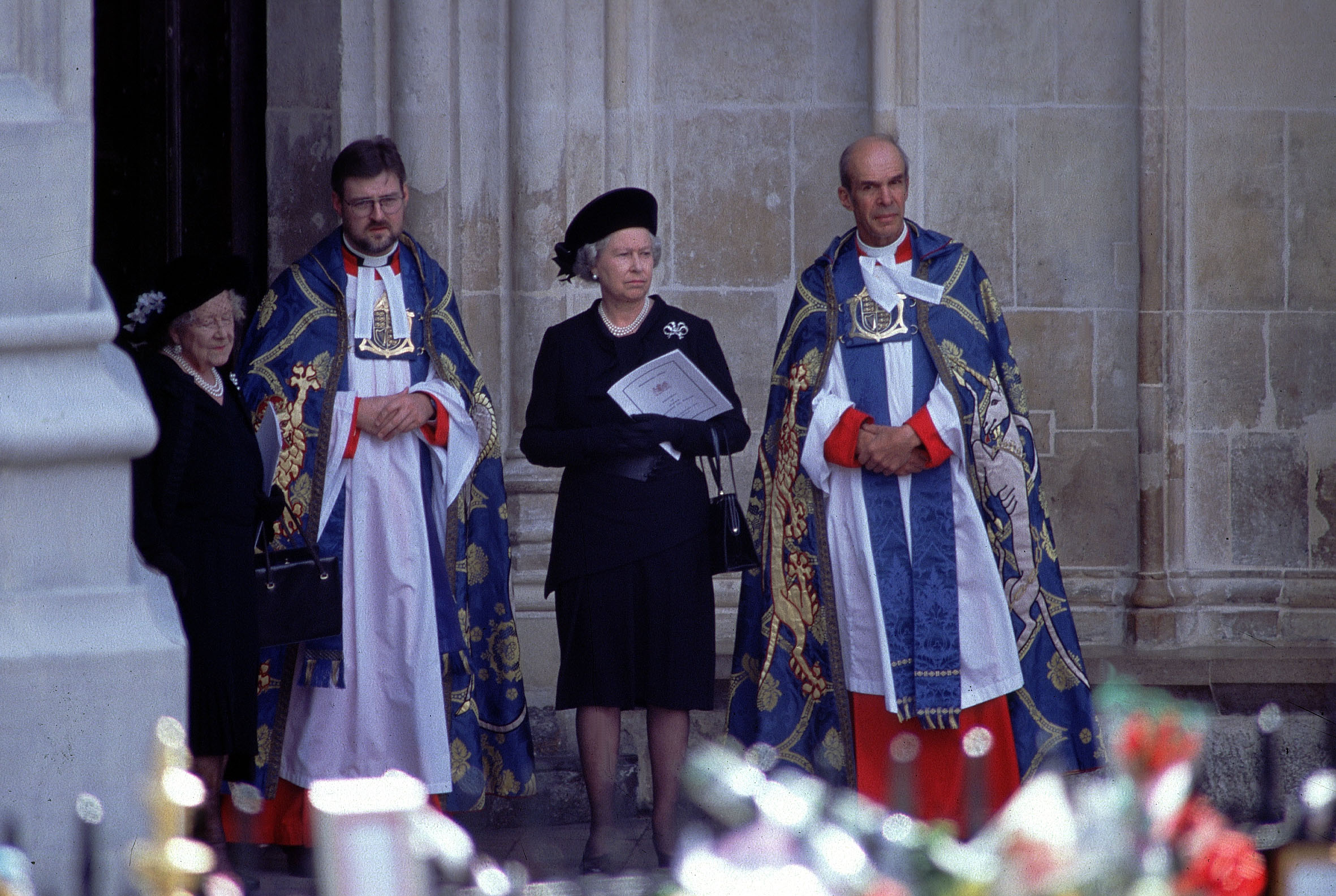 Queen Elizabeth and the Queen Mother standing with priests outside Westminster Abbey at Princess Diana's funeral