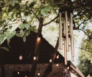 Wind chimes in a tree in front of solar lights