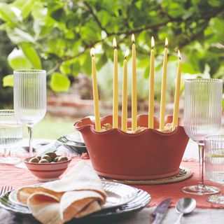 DIY candle centrepiece in terracotta pot on table in garden